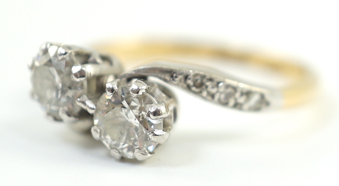 A mid 20th century 18ct gold, platinum and two stone diamond set crossover ring